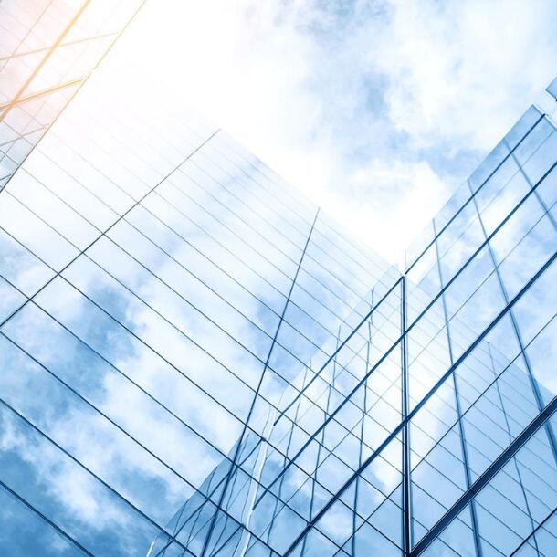 An upward shot of a glass building with many windows