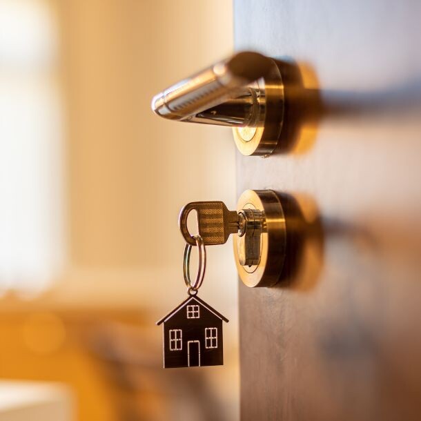 Key with a keychain in lock on a wooden door