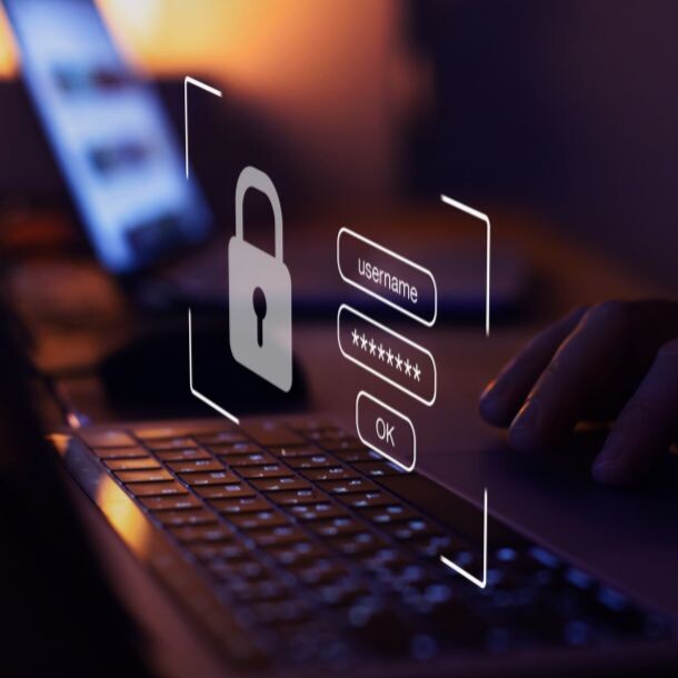 In a dimly lit picture sits a laptop, above it is a white set of icons representing the login interface.