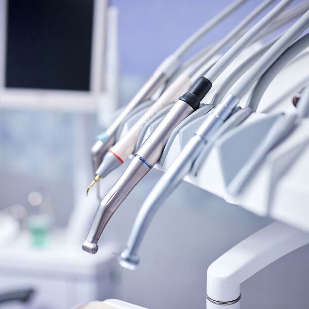 Closeup of four metal dentist tools sitting at the plastic white support.