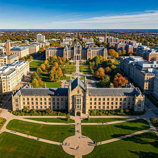 Wide shot of a college campus that involves large green areas.