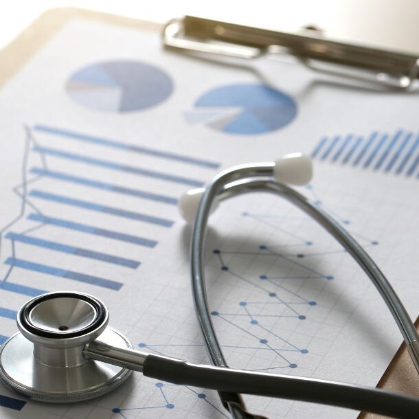 A stethoscope lying on top of a clipboard with reports.
