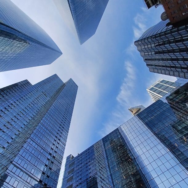 A shot from the ground up facing skyscrapers against the sky.