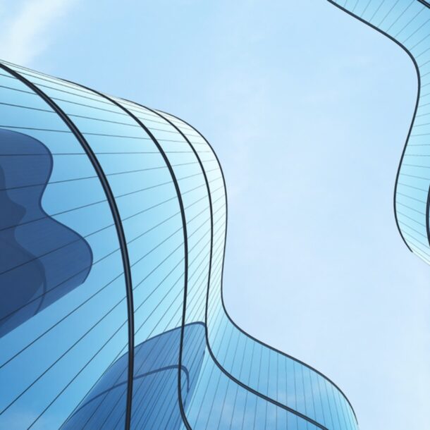Shot from the ground up, wave-shaped skyscrapers in contrast wiht the sky.