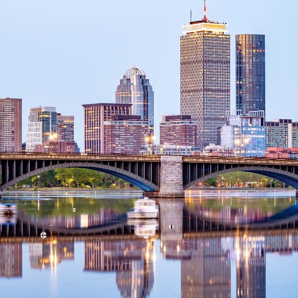 Longfellow Bridge spanning the Charles River with the Boston skyline reflected in the water at dusk