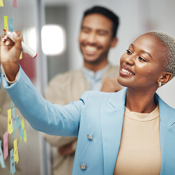 Businesswoman writing ideas and planning in a meeting.