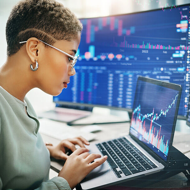 Businesswoman reading investment and IPO analytics on a laptop.