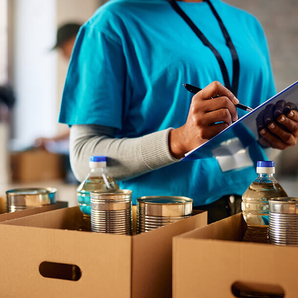 Female volunteer making a list of food supplies at a humanitarian aid center.