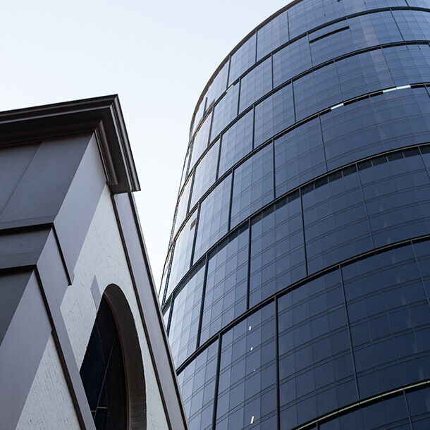 Tall commercial office towers against a blue sky representing real estate.