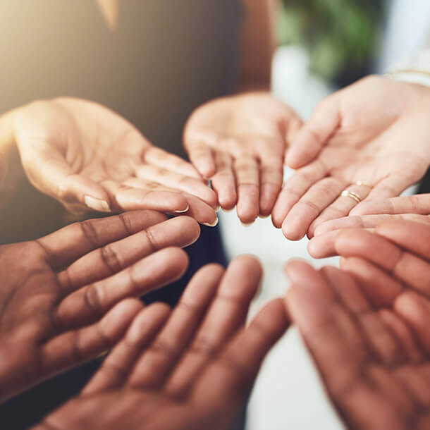 Business professionals with open hands representing non-profit community support.