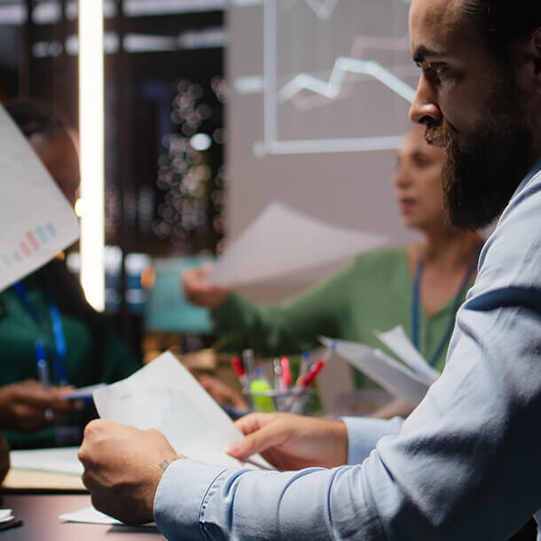 Diverse project team shares analytics reports during an advisory board event.